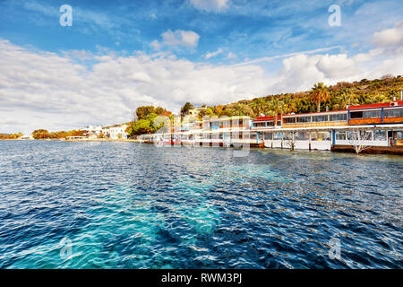 Vista del paesaggio di ristoranti di pesce in riva al mare su una soleggiata giornata invernale in Gumusluk, Bodrum, Mugla, Turchia. Foto Stock