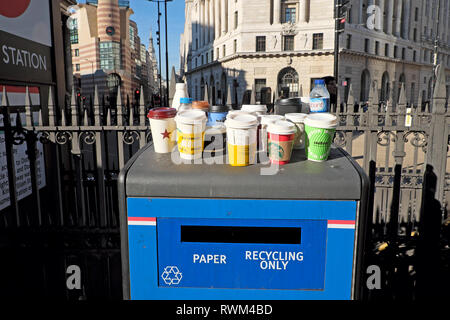 Carta e plastica vuota bicchieri e bottiglie di plastica in piedi su un riciclaggio della carta solo il bidone dei rifiuti stazione della metropolitana di Bank nella città di Londra UK KATHY DEWITT Foto Stock