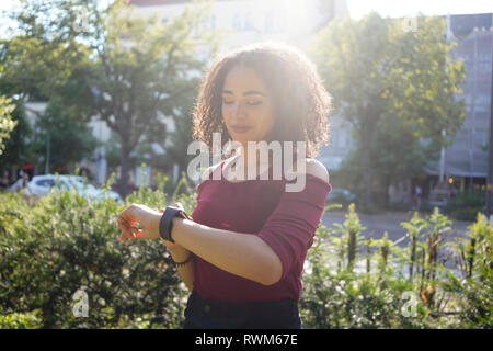 Giovane donna tempo di controllo, Berlino, Germania Foto Stock