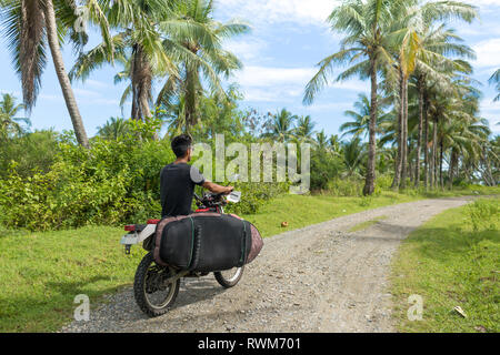 Motociclista con tavola da surf, Abulug, Cagayan, Filippine Foto Stock