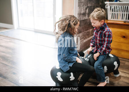 Bambini che giocano sul giocattolo gonfiabile a casa Foto Stock