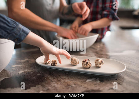 Bambini godendo appena sfornato sementi vegetariano sfere Foto Stock