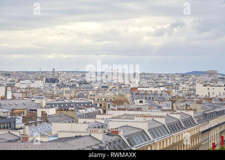 Tetti di Parigi e la vista dello skyline della città in un giorno nuvoloso con fascio di Sun in Francia Foto Stock