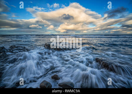 Onde infrangersi su scogli lungo la costa dell'Islanda, a ovest di fiordi, Islanda Foto Stock