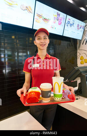 KALININGRAD, RUSSIA - circa settembre, 2018: lavoratore con cibo servito su un vassoio nel ristorante McDonald's. McDonald è un americano di fast food company. Foto Stock