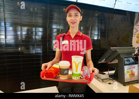 KALININGRAD, RUSSIA - circa settembre, 2018: lavoratore con cibo servito su un vassoio nel ristorante McDonald's. McDonald è un americano di fast food company. Foto Stock