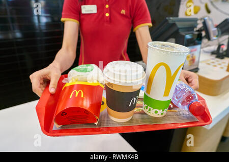 KALININGRAD, RUSSIA - circa settembre, 2018: lavoratore con cibo servito su un vassoio nel ristorante McDonald's. McDonald è un americano di fast food company. Foto Stock