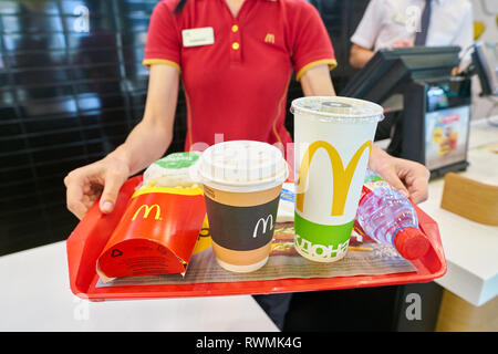 KALININGRAD, RUSSIA - circa settembre, 2018: lavoratore con cibo servito su un vassoio nel ristorante McDonald's. McDonald è un americano di fast food company. Foto Stock