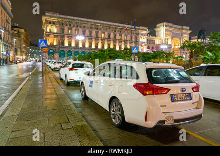 Milano, Italia - circa novembre, 2017: bianco taxi a Milano durante la notte. Milano è una città del nord Italia. Foto Stock