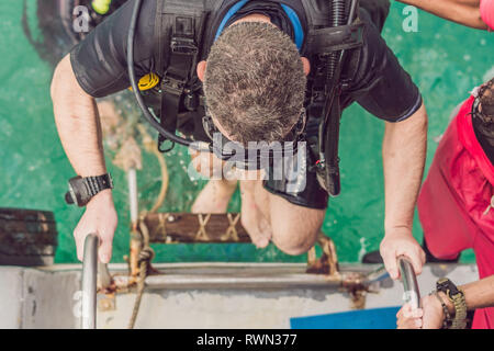 Felice subacqueo ritorna alla nave dopo le immersioni Foto Stock