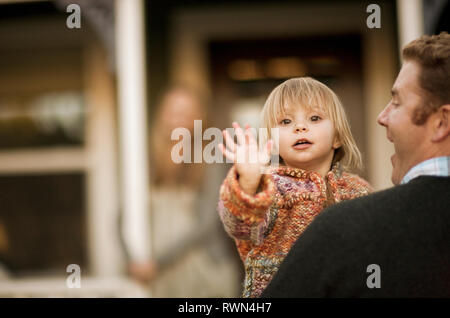 Ragazza giovane sventolando la fotocamera nel suo padri bracci. Foto Stock