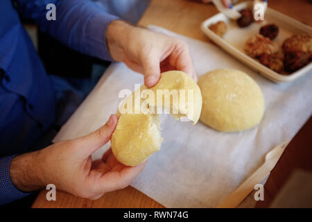 L'uomo mani appena sfornato pane soffice rotolo. Fast food. Ristorante Foto Stock