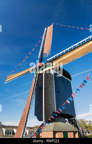 Guardando il vecchio mulino a vento in legno con contrassegno di lungo le sue vele e il profondo blu del cielo; Leiden, Paesi Bassi Foto Stock