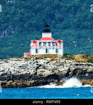 Uovo faro di roccia con il Parco Nazionale di Acadia dietro di essa e acqua schiantarsi sulla sua riva di fronte ad esso in Bar Harbor, Maine. Foto Stock
