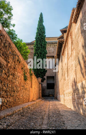 Svuotare stretto vicolo pavimentato con ciottoli tra le antiche mura di Alhambra Palace Foto Stock