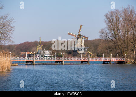 Rotterdam, Paesi Bassi - 17 Marzo 2016: il mulino a vento con il lago e un ponte a Kralingse Bos a Rotterdam, Paesi Bassi Foto Stock