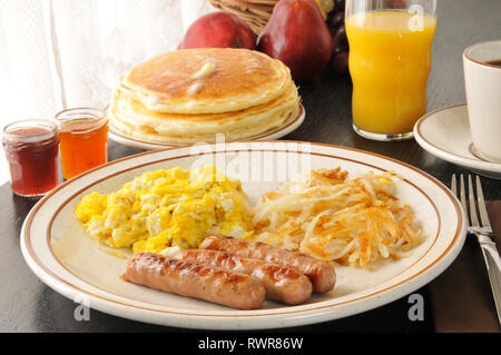 Salsicce e uova strapazzate con hash browns e pancake Foto Stock