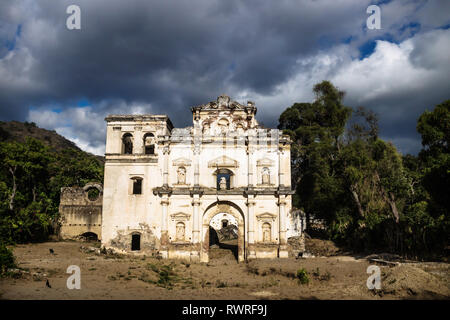 Facciata della chiesa rovina sotto drammatico cloudscape blu, Antigua, Guatemala Foto Stock