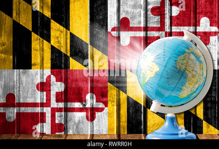 Globo con una mappa del mondo su un sfondo di legno con l'immagine dello Stato di bandiera del Maryland. Il concetto di viaggio e il tempo libero all'estero. Foto Stock