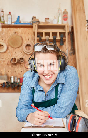 Felice giovane donna come un artigiano partecipante per lavori di falegnameria o lavori di falegnameria Foto Stock