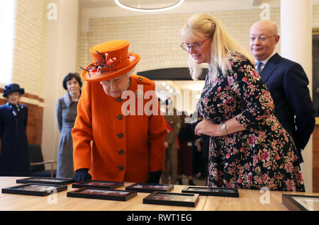 La regina Elisabetta II è mostrato fotografie della famiglia reale di visite precedenti, come il Museo della Scienza Direttore Ian Blatchford guarda, durante la visita al museo per l'annuncio della loro esposizione estiva "Top Secret" in Kensington, Londra. Foto Stock