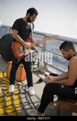 Banda libanese' Mashrou Leila impostare e preparatevi a registrare un brano a bordo di Greenpeace Rainbow Warrior nave su Il Sole ci unisce tour, Mare Mediterraneo, il 23 ottobre 2016. N38°01.545' E9°45.487' Foto Stock