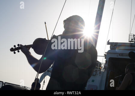 Banda libanese' Mashrou Leila impostare e preparatevi a registrare un brano a bordo di Greenpeace Rainbow Warrior nave su Il Sole ci unisce tour, Mare Mediterraneo, il 23 ottobre 2016. N37°56.441' E8°51.015' Foto Stock