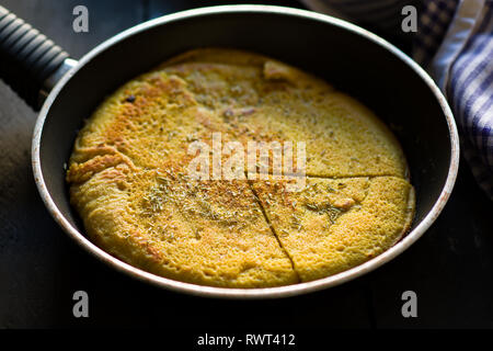 Affettato Vegan frittata di ceci su una padella Foto Stock