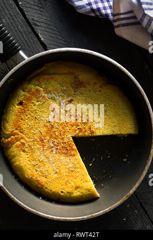 Affettato Vegan frittata di ceci su una padella Foto Stock