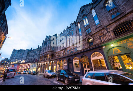 Vista del tramonto di edifici di interesse storico e i negozi di Victoria Street di Edimburgo città vecchia, Scotland, Regno Unito Foto Stock