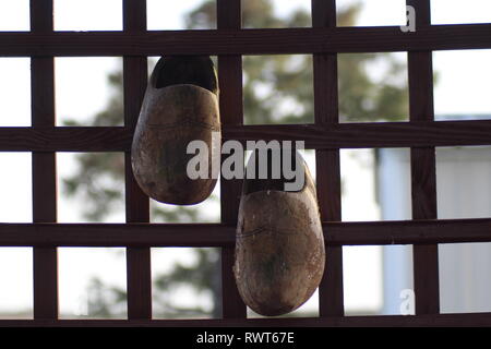 Scarpe di legno decorare un giardino patio Foto Stock