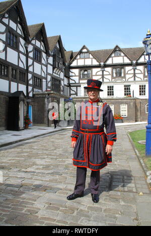 Un Beefeater sorge di fronte al Queens House presso la Torre di Londra. Si tratta di una giornata di sole e lui è in guardia Foto Stock