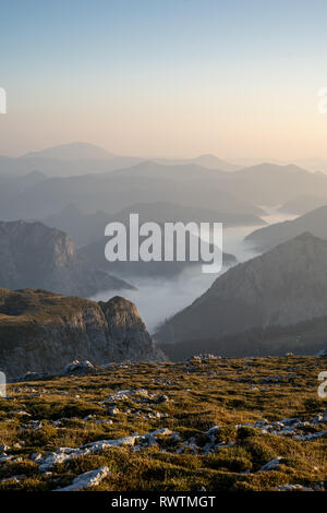 La valle di nebbia accanto all'Hochschwab moutain nelle prime ore del mattino, Austria Foto Stock