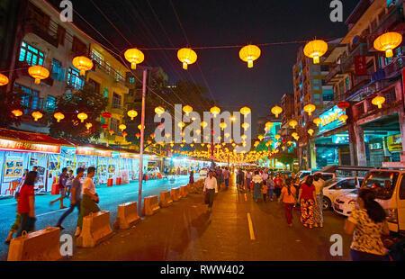 YANGON, MYANMAR - 15 febbraio 2018: la passeggiata serale lungo le affollate Maha Bandula Road, decorato con il nuovo anno cinese lanterne, il 15 febbraio ho Foto Stock