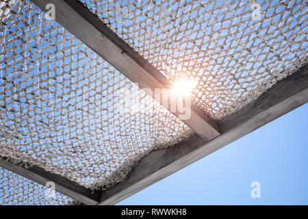 Il baldacchino del sole sotto il cielo blu con sole splendente Foto Stock