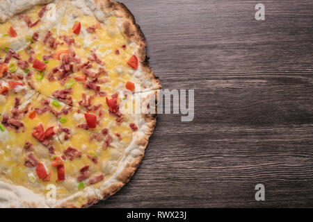 Pizza artigianale contro il legno scuro dello sfondo. Copyspace pizza. Fatte a mano Foto Stock