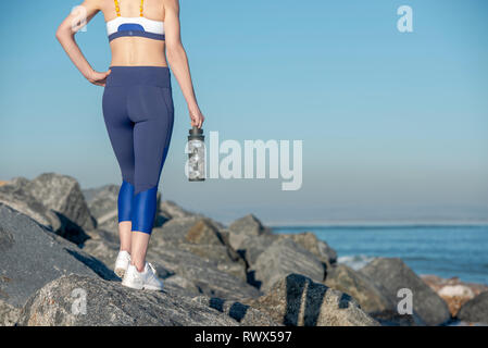 In prossimità di uno sport di acqua in bottiglia, womans gambe in gambali di abbigliamento sportivo Foto Stock