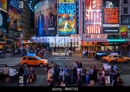 Luminose insegne al neon lampeggia su folle e taxi traffico passato zoom Times Square il luogo di ritrovo della città famosa di nuovo. Foto Stock