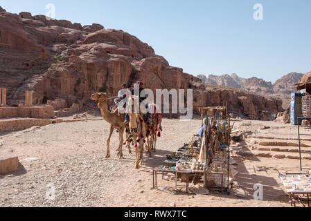 PETRA, GIORDANIA - Maggio 17, 2018: Araba guida beduina in sella al suo cammello nel patrimonio mondiale di UNESCO sito di Petra Foto Stock