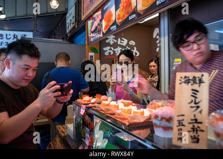 Po' di tapas, hibachi, e il ristorante di sushi vicino all'enorme il Mercato del Pesce di Tsukiji a Tokyo in Giappone, la visualizzazione di un enorme tonno e foto di pasti e loro Foto Stock