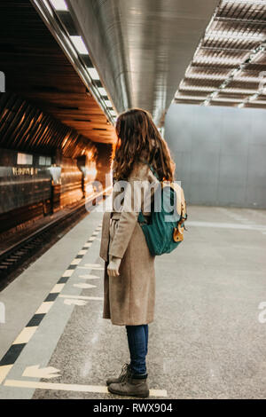 Giovane donna ricci testa rossa ragazza viaggiatori con zaino e mappa nella stazione della metropolitana Foto Stock