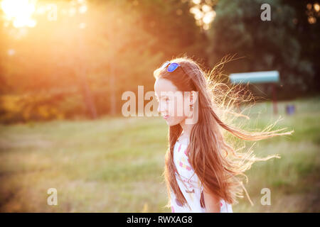 Bella ragazza Teen è godersi la natura nel parco al tramonto in estate Foto Stock