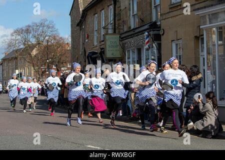 Foto datata 5 marzo mostra i mondi più antico pancake gara che si svolge su strade di Olney,Bucks,martedì mattina. Più di 2000 persone a pranzo per le strade di Olney nel Buckinghamshire per vedere 25 townswomen vestito come casalinghe, competere nella più antica pancake gara nel mondo di oggi (martedì). Le donne indossavano gonne, grembiuli e sciarpe di testa mentre correvano con skillets e pancakes al traguardo nella 574-anno-vecchio gara nella piccola città di mercato. La storica Martedì Grasso gara, iniziata nel 1445, è aperto alle donne over 18 che hanno vissuto nella pittoresca città per più di tre Foto Stock