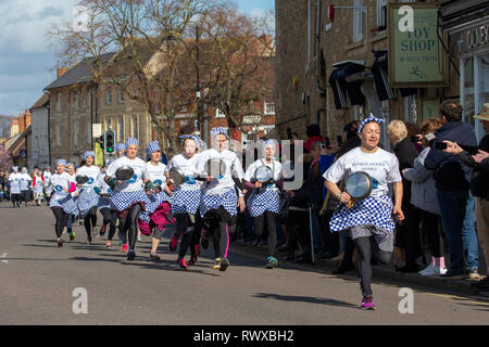 Foto datata 5 marzo mostra i mondi più antico pancake gara che si svolge su strade di Olney,Bucks,martedì mattina. Più di 2000 persone a pranzo per le strade di Olney nel Buckinghamshire per vedere 25 townswomen vestito come casalinghe, competere nella più antica pancake gara nel mondo di oggi (martedì). Le donne indossavano gonne, grembiuli e sciarpe di testa mentre correvano con skillets e pancakes al traguardo nella 574-anno-vecchio gara nella piccola città di mercato. La storica Martedì Grasso gara, iniziata nel 1445, è aperto alle donne over 18 che hanno vissuto nella pittoresca città per più di tre Foto Stock