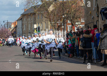 Foto datata 5 marzo mostra i mondi più antico pancake gara che si svolge su strade di Olney,Bucks,martedì mattina. Più di 2000 persone a pranzo per le strade di Olney nel Buckinghamshire per vedere 25 townswomen vestito come casalinghe, competere nella più antica pancake gara nel mondo di oggi (martedì). Le donne indossavano gonne, grembiuli e sciarpe di testa mentre correvano con skillets e pancakes al traguardo nella 574-anno-vecchio gara nella piccola città di mercato. La storica Martedì Grasso gara, iniziata nel 1445, è aperto alle donne over 18 che hanno vissuto nella pittoresca città per più di tre Foto Stock