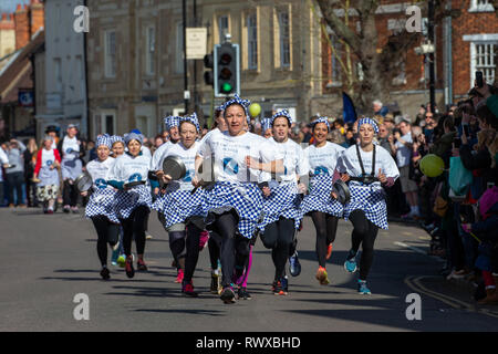 Foto datata 5 marzo mostra i mondi più antico pancake gara che si svolge su strade di Olney,Bucks,martedì mattina. Più di 2000 persone a pranzo per le strade di Olney nel Buckinghamshire per vedere 25 townswomen vestito come casalinghe, competere nella più antica pancake gara nel mondo di oggi (martedì). Le donne indossavano gonne, grembiuli e sciarpe di testa mentre correvano con skillets e pancakes al traguardo nella 574-anno-vecchio gara nella piccola città di mercato. La storica Martedì Grasso gara, iniziata nel 1445, è aperto alle donne over 18 che hanno vissuto nella pittoresca città per più di tre Foto Stock