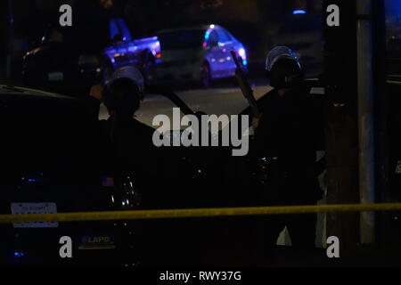 Los Angeles, CA / STATI UNITI D'America - 6 Marzo 2019: due Los Angeles il dipartimento di polizia (aka LAPD) ufficiali sono mostrati in attesa durante uno standoff in un residence a Burbank Blvd. in North Hollywood. Entrambi agenti indossano caschi antisommossa con schermi facciali e uno è rappresentato con un fucile da caccia. Credito: Kilmer Media/Alamy Live News Foto Stock