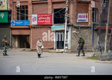 Srinagar, Jammu e Kashmir in India. 8 Mar, 2019. Un vecchio uomo visto a piedi passato paramilitari indiano troopers guardia durante le restrizioni nell'area del centro cittadino di Srinagar.competenti imposto restrizioni nelle parti di Srinagar Kashmir per impedire la protesta chiamato da una resistenza comune Leadership (JRL) contro la detenzione di Jammu e Kashmir Liberation Front presidente Yasin Malik e l' arresto del gruppo Jamaat-e-Islamia quadri. Credito: Idrees Abbas SOPA/images/ZUMA filo/Alamy Live News Foto Stock