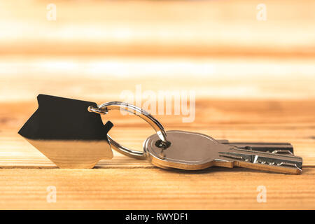 Le chiavi di casa su uno sfondo di legno Foto Stock