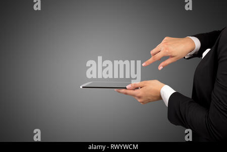 Mano femminile in tuta azienda tablet con nessun wallpaper Foto Stock